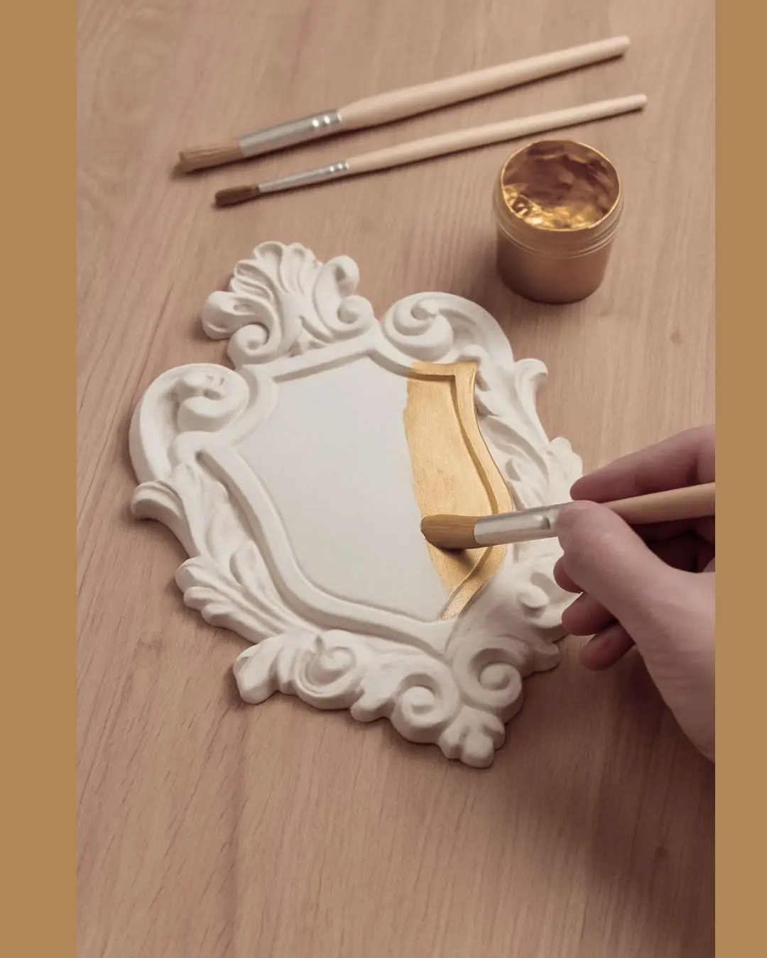 Proceso de pintura artesanal de un escudo de escayola con pincel y acabado dorado Proceso de pintura artesanal de un escudo de escayola con pincel y acabado dorado