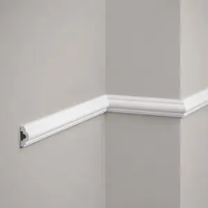 Moldura decorativa blanca MD002 instalada sobre pared gris claro